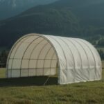 Mobile Rundbogenhalle als fliegender Bau auf Wiese vor Bergen